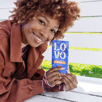 Woman enjoying LOVO's Dairy-Free Oat Milk Chocolate Bar