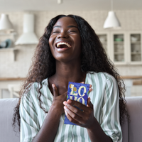 Young woman at home enjoying a bar of Lovo Coconut Milk chocolate